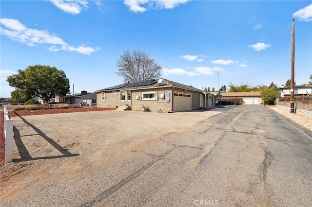 single story home featuring a garage and solar panels