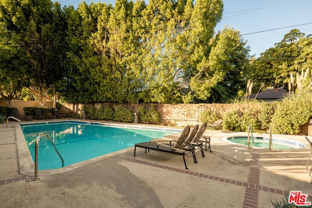 view of pool featuring an in ground hot tub and a patio