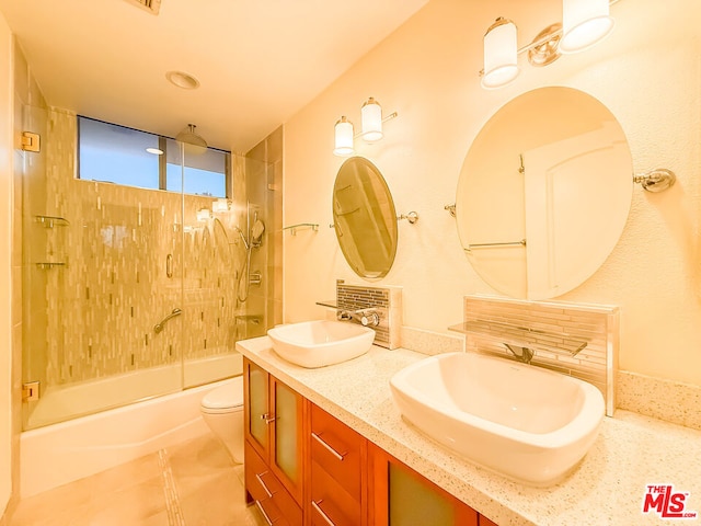 full bathroom with toilet, tiled shower / bath, and vanity