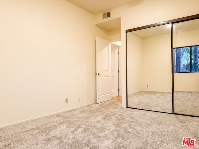 unfurnished bedroom with a closet and carpet flooring