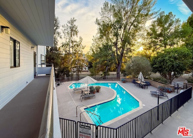 pool at dusk with a patio