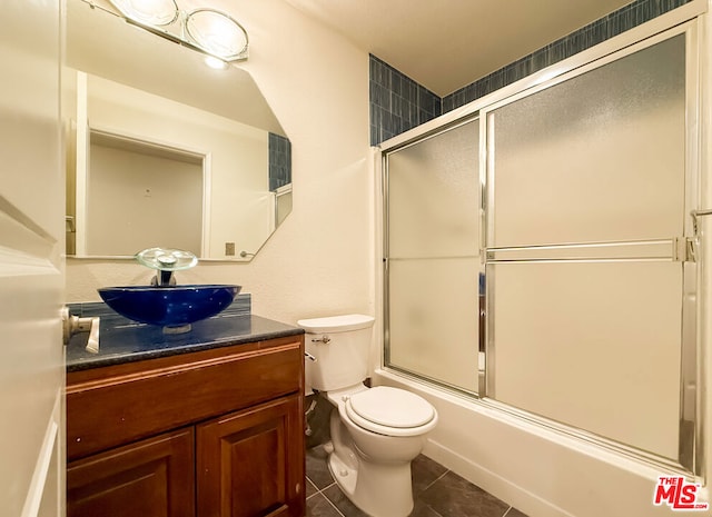 full bathroom featuring vanity, toilet, enclosed tub / shower combo, and tile patterned flooring