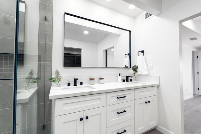 bathroom with vanity and a tile shower