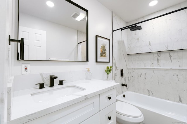 full bathroom with tiled shower / bath combo, vanity, and toilet