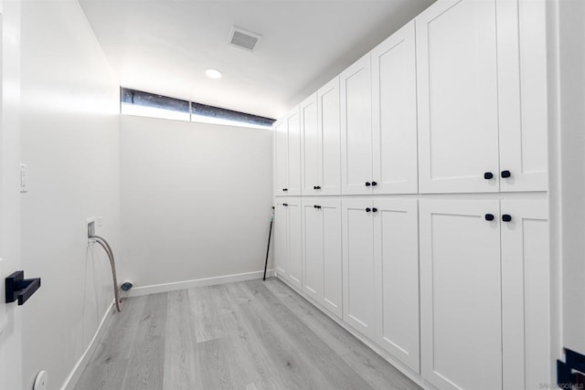 laundry area with cabinets, washer hookup, and light hardwood / wood-style flooring