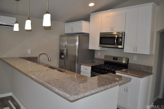 kitchen featuring white cabinets, appliances with stainless steel finishes, decorative light fixtures, sink, and kitchen peninsula