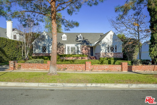 cape cod home with a front yard