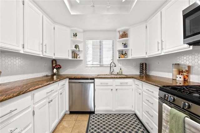 kitchen featuring white cabinetry, stainless steel appliances, sink, and dark stone counters