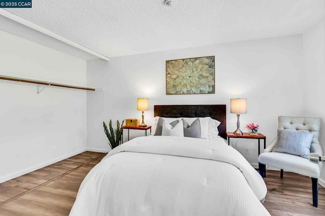 bedroom featuring hardwood / wood-style floors and a textured ceiling