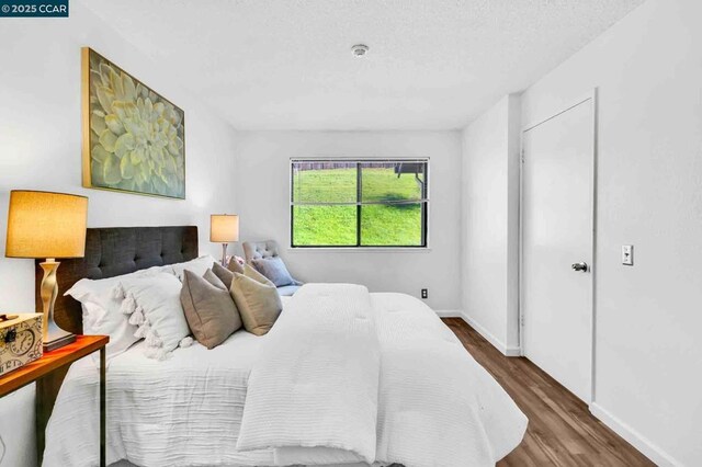 bedroom featuring hardwood / wood-style floors and a textured ceiling