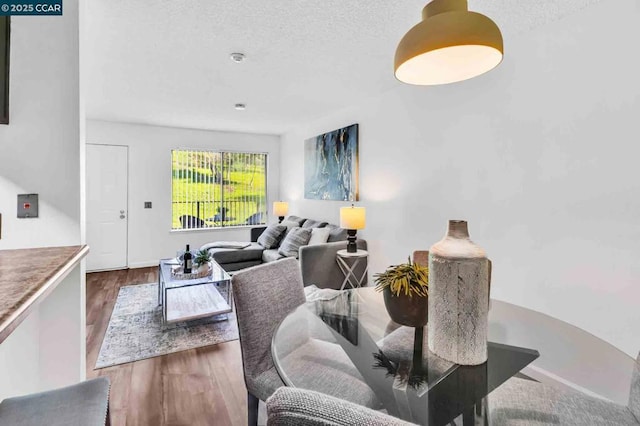 dining room with hardwood / wood-style flooring and a textured ceiling