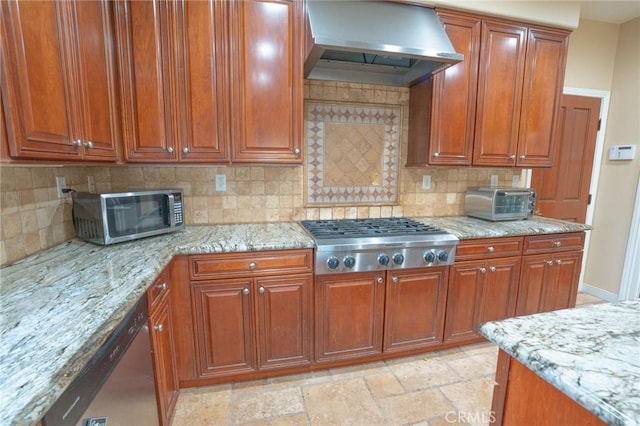 kitchen with stainless steel appliances, light stone countertops, extractor fan, and decorative backsplash