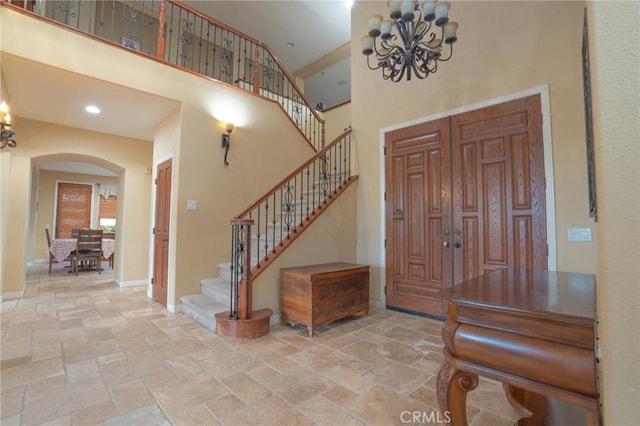 foyer featuring an inviting chandelier and a high ceiling