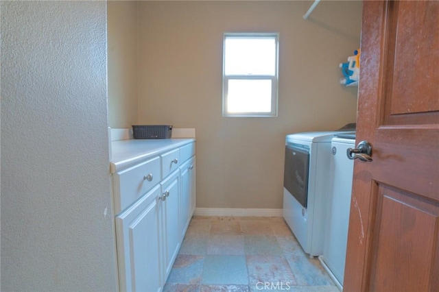 washroom with cabinets and washing machine and dryer