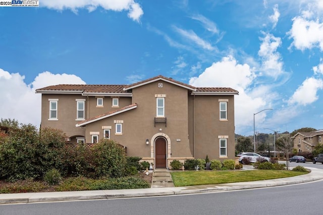 mediterranean / spanish home featuring a front lawn