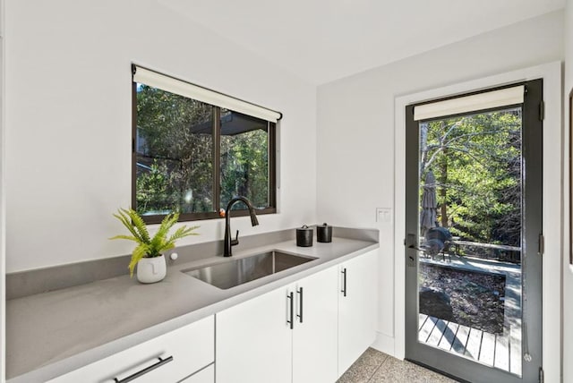 kitchen featuring white cabinetry and sink