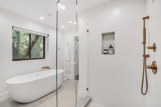 bathroom with tile patterned floors and shower with separate bathtub