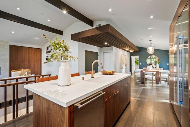 kitchen featuring sink, vaulted ceiling with beams, wood-type flooring, a center island with sink, and stainless steel dishwasher