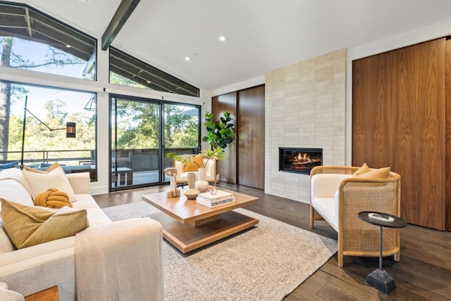 living room with dark wood-type flooring, a fireplace, wooden walls, and vaulted ceiling with beams