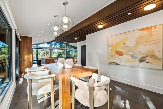 dining space with lofted ceiling, floor to ceiling windows, and dark hardwood / wood-style flooring