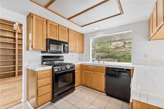 kitchen featuring sink, black appliances, tile countertops, and light tile patterned flooring