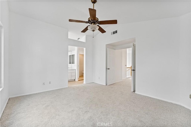 carpeted spare room featuring vaulted ceiling and ceiling fan