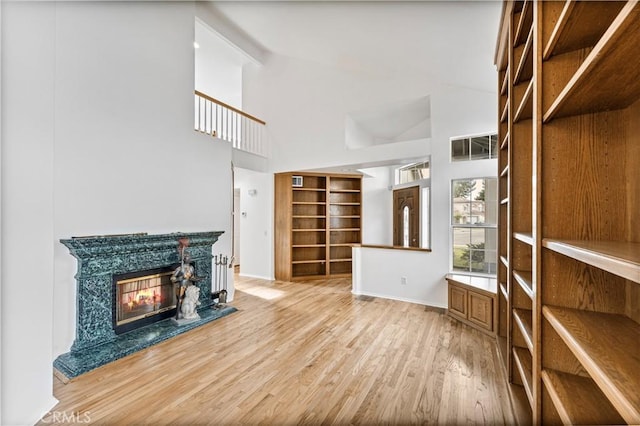 interior space with hardwood / wood-style flooring, high vaulted ceiling, and a fireplace