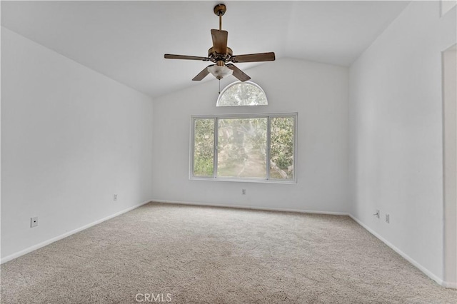 carpeted spare room featuring vaulted ceiling and ceiling fan