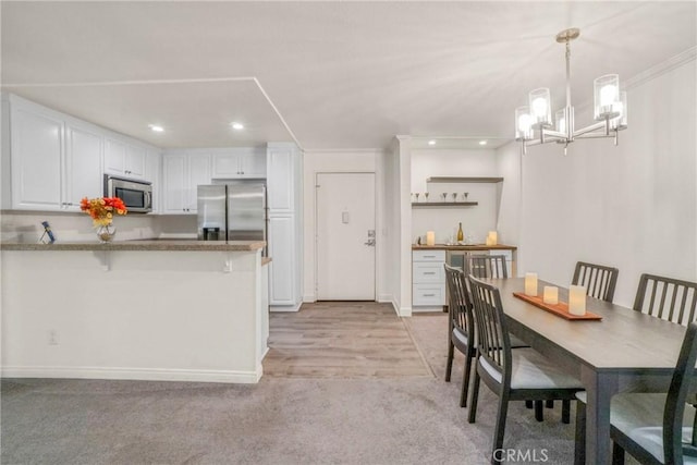 kitchen with a kitchen bar, white cabinetry, hanging light fixtures, appliances with stainless steel finishes, and kitchen peninsula