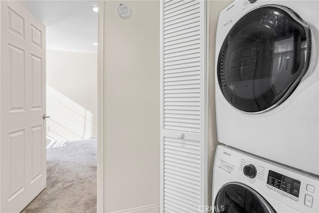 washroom featuring light colored carpet and stacked washer / drying machine