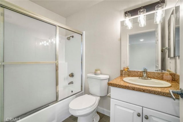 full bathroom featuring vanity, combined bath / shower with glass door, and toilet