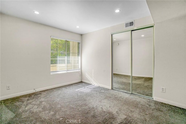 unfurnished bedroom featuring carpet floors and a closet