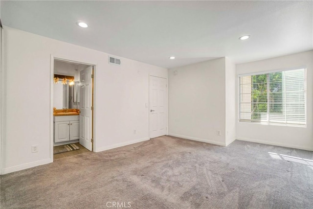 unfurnished bedroom with light carpet and ensuite bath