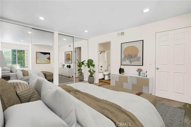 bedroom featuring multiple closets and ensuite bathroom