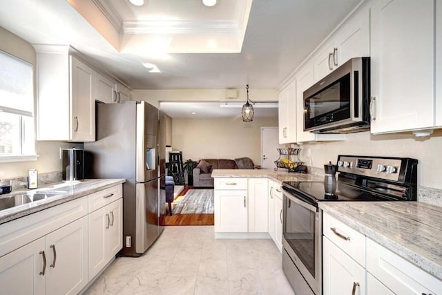 kitchen featuring stainless steel appliances, white cabinetry, and a raised ceiling