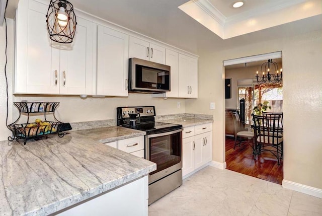 kitchen with crown molding, appliances with stainless steel finishes, white cabinetry, pendant lighting, and light stone counters