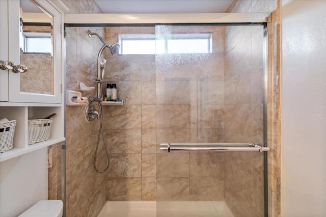 bathroom featuring plenty of natural light, toilet, and walk in shower