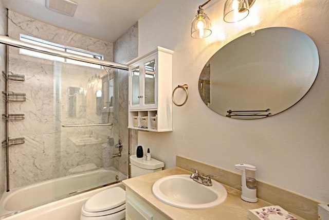 full bathroom featuring toilet, shower / bath combination with glass door, and vanity