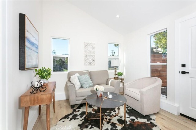 sitting room with vaulted ceiling and light wood-type flooring