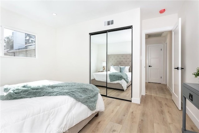 bedroom with light hardwood / wood-style flooring and a closet