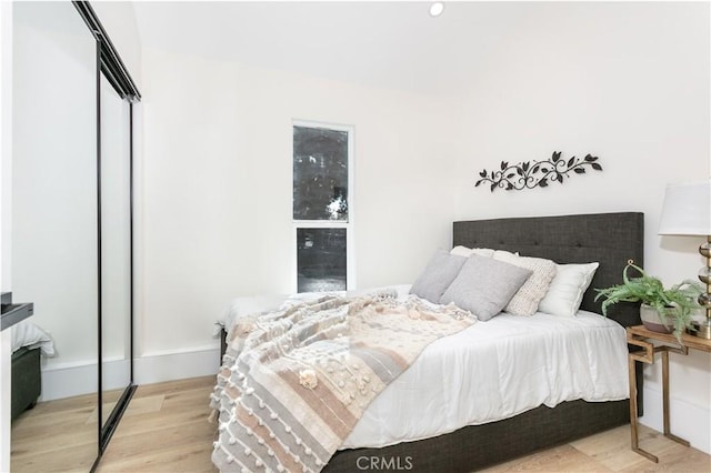 bedroom with a closet and light hardwood / wood-style flooring