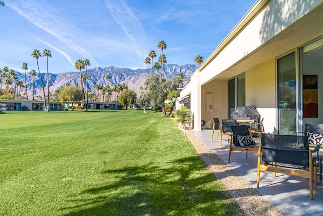 view of yard featuring a mountain view and a patio