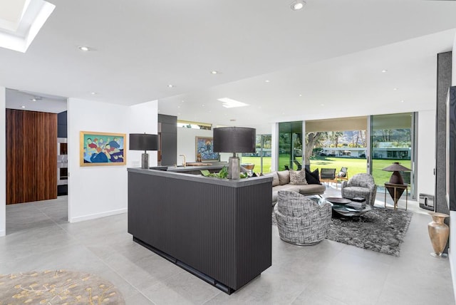 living room with expansive windows and a skylight