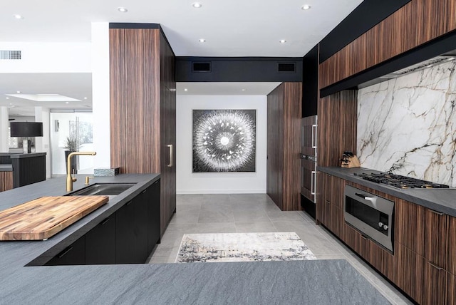 kitchen featuring sink, dark brown cabinets, tasteful backsplash, and stainless steel appliances