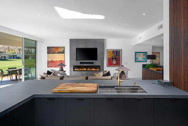 interior space featuring sink, a large fireplace, and a skylight