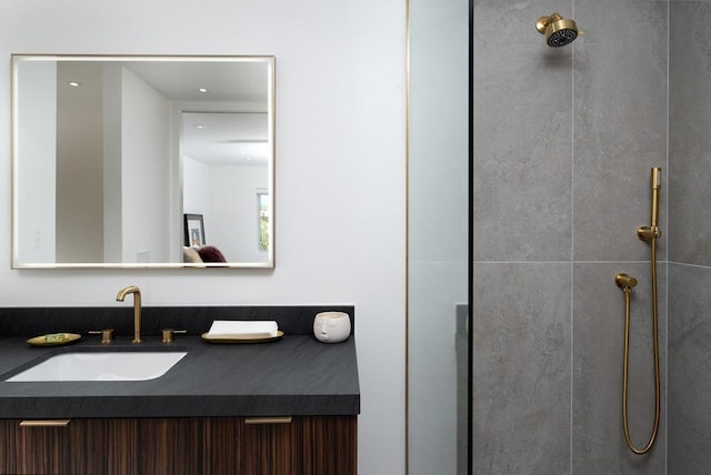 bathroom with tiled shower and vanity