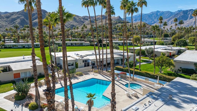 view of pool with a mountain view, a patio area, and a community hot tub