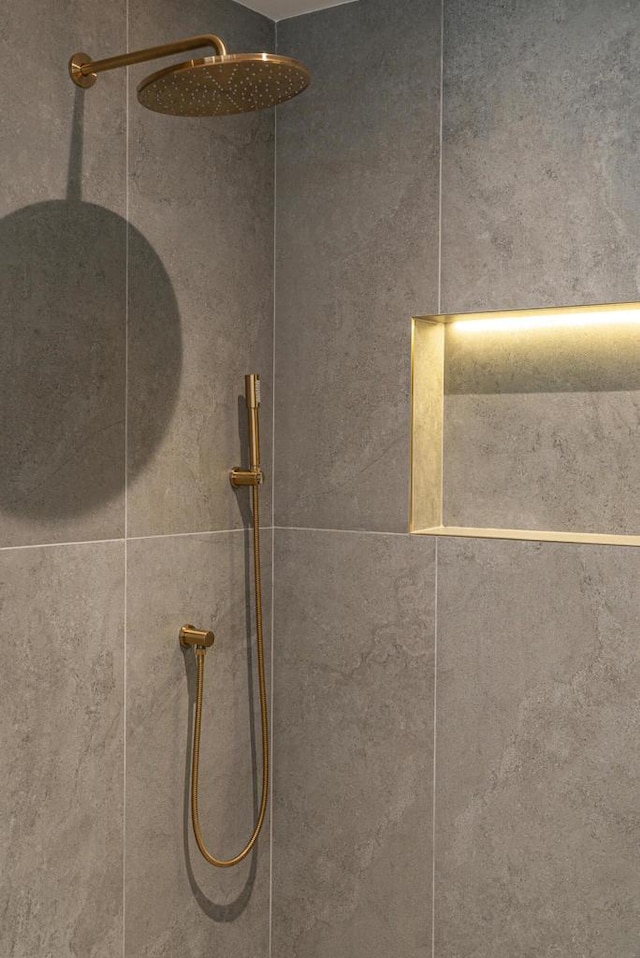 interior details featuring a tile shower