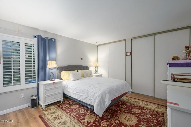 bedroom with multiple closets and light wood-type flooring