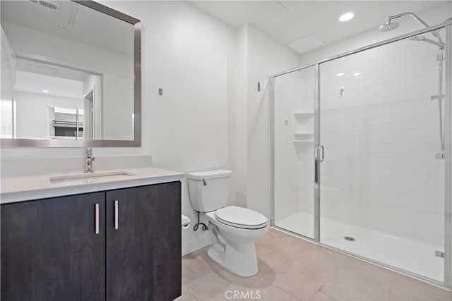 bathroom featuring a shower with shower door, toilet, vanity, and tile patterned flooring